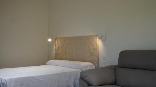 a room with two beds and a couch and a chair at Lorca Express Suite in Lorca