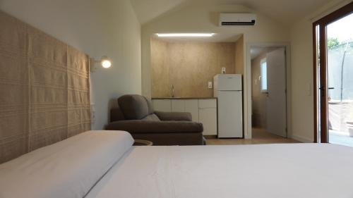 a bedroom with a bed and a chair and a refrigerator at Lorca Express Suite in Lorca