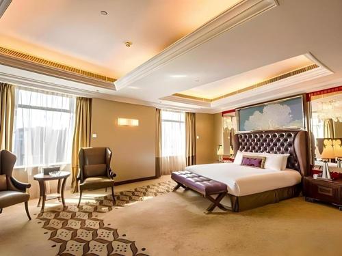 a hotel room with a bed and two chairs at Hotel Lisboa in Macau