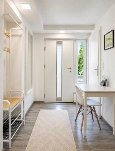a white dining room with a table and chairs at Cozy Apartment with Terrace & Free Parking in Würzburg