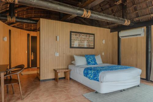 a bedroom with a bed and a table and a chair at Le Lagoto Resort & Spa in Fagamalo