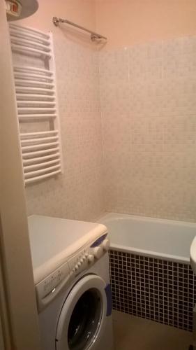 a bathroom with a washing machine and a bath tub at Lucas Apartment - Self check-in in Bratislava