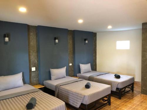three beds in a room with blue walls at CoCo Tree Resort in Thap Sakae