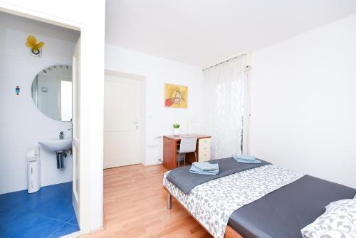 a bedroom with a bed and a bathroom with a sink at Jelena - Spacious Sea View Apartment - Old Town Zadar in Zadar