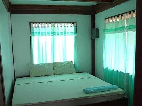 a bed in a room with a window at Mayas Native Garden Resort in Basdiot