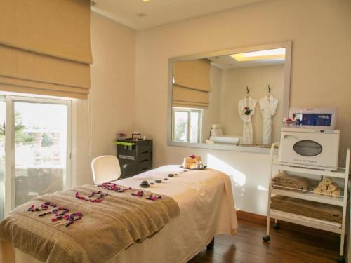 a bedroom with a bed with pink flowers on it at Gulf Pearls Hotel in Doha