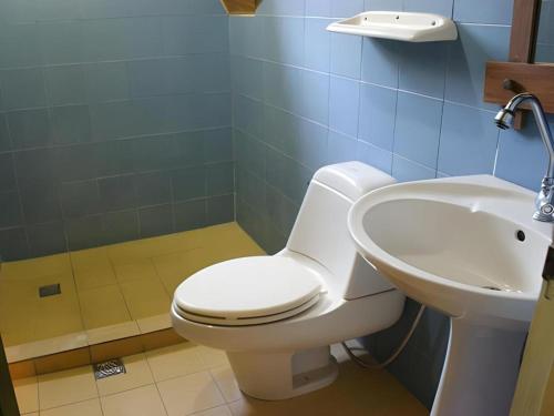 a bathroom with a toilet and a sink at Pineapple Island Resort in Badas
