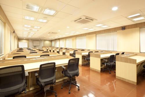 a large room with rows of tables and chairs at GP Hotels and Resorts in Nashik