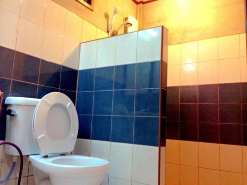 a bathroom with a toilet with blue and white tiles at Zigzag Resort in Ban Som Poi