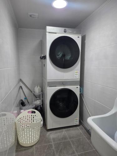 a washer and dryer in the corner of a bathroom at 고요스테이 in Chuncheon