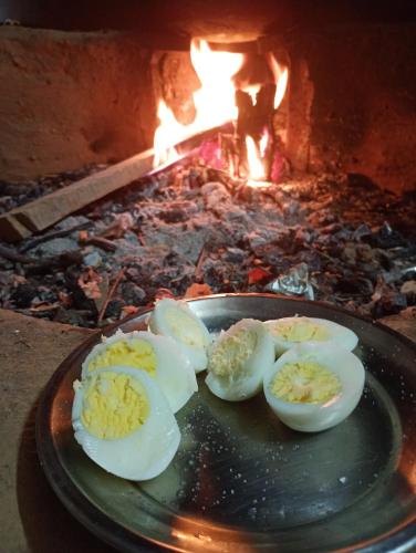 four eggs on a plate in front of an oven at DnD cottages in Mandi