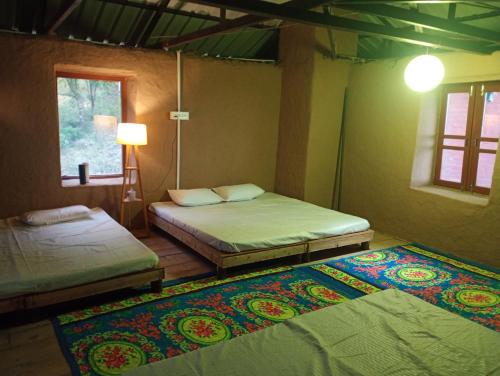 a bedroom with two beds and a rug on the floor at DnD cottages in Mandi
