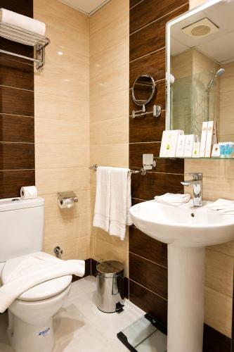 a bathroom with a toilet and a sink at Maysan Al Safa Hotel in Mecca