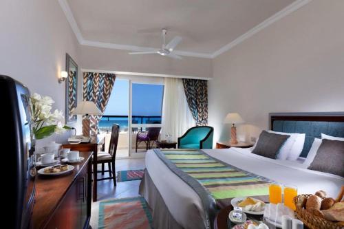 a hotel room with a bed and a view of the ocean at Borg El Arab Beach Resort in Dawwār ‘Abd al Qādir Qāsim