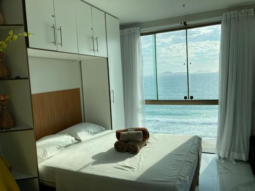 a teddy bear laying on a bed in a bedroom at Loft da Prainha in Arraial do Cabo