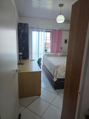 a bedroom with a bed and a large window at Pousada de Isa in Palhoça