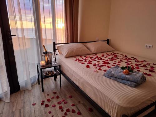 a bedroom with a bed with red roses on it at Студия у чистейшего Моря! in Gonio
