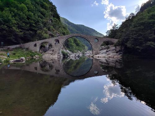 a bridge over a river with its reflection in the water at Central Grevena Retreat with Mountain Views in Grevena