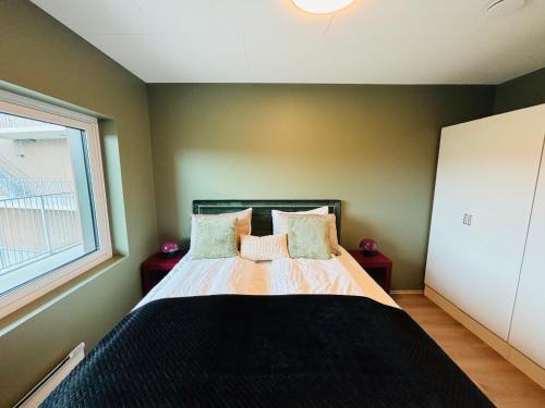 a bedroom with a bed with two pillows and a window at Arctic Privé Panorama Residence Alta in Alta