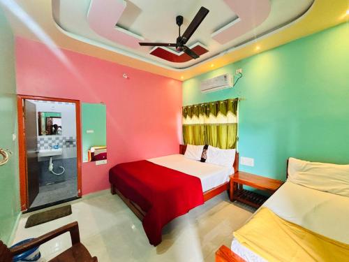 a bedroom with two beds and a ceiling fan at Hampi Icon Palace in New Hampi