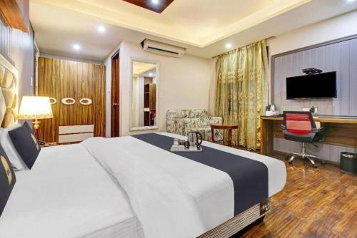 a hotel room with a large bed and a desk at Saffron by Stay Pattern - City Center in Srinagar