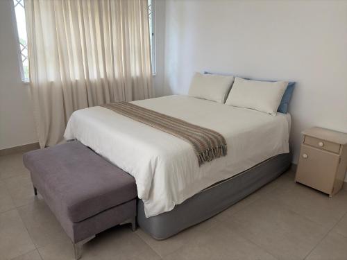 a bedroom with a large bed with a chair at 2 bedrooms Ngubelanga Stays in Margate