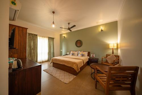 a bedroom with a bed and a chair in a room at The Elegant homes in Kushālnagar