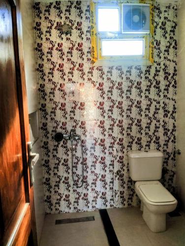 a bathroom with a toilet and floral wallpaper at Quiet place in Dahab