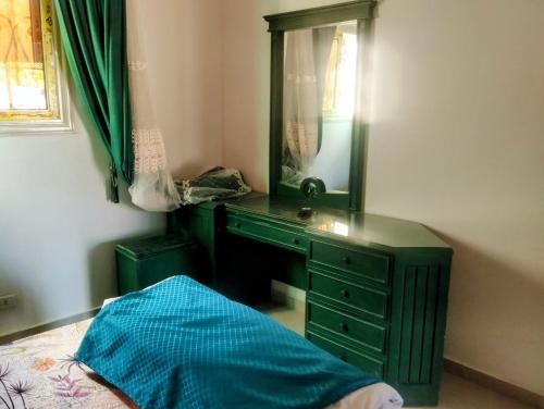 a bedroom with a green dresser and a mirror at Quiet place in Dahab