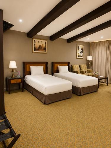 a hotel room with two beds and a couch at Desert Inn Resort and Camp in Ras al Khaimah