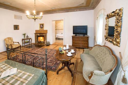 a living room with a couch a table and a television at Chateau GrandCastle in Liptovský Hrádok