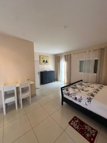 a bedroom with a bed and two chairs and a desk at New White House in Saly Portudal