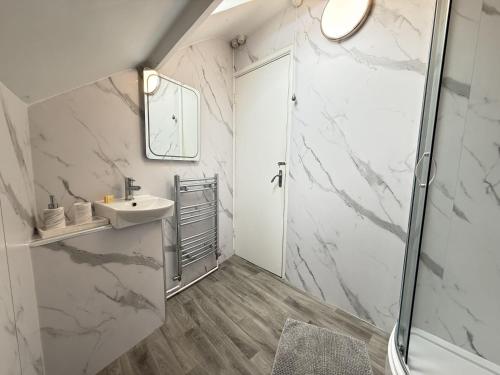 a bathroom with a sink and a shower at Crows Nest - panoramic views of St Ives harbour in St Ives