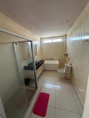 a bathroom with a shower and a toilet and a sink at New White House in Saly Portudal