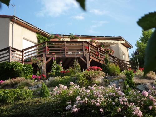 a garden with flowers and a wooden bridge at Les Terrasses de Bellemoure Cébazat in Cébazat