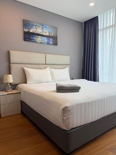a bedroom with a large white bed with a large window at VORTEX SUITES KLCC By SKYLINE in Kuala Lumpur