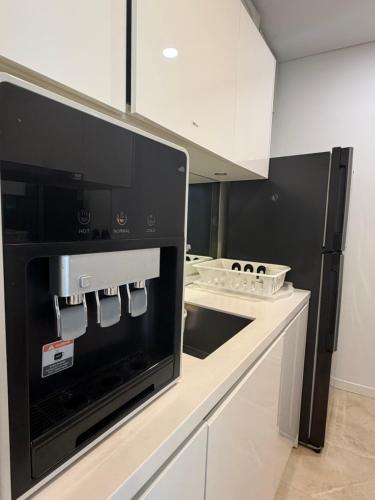a kitchen with a black and white appliance at VORTEX SUITES KLCC By SKYLINE in Kuala Lumpur