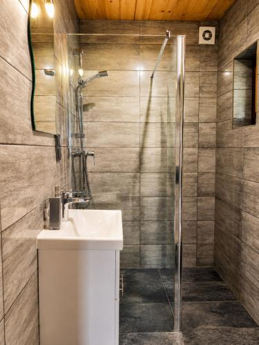 a bathroom with a sink and a shower at Domek Pod Tylką in Grywałd