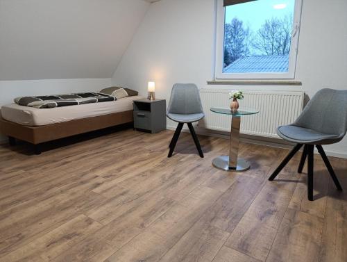 a bedroom with a bed and two chairs and a table at Landhaus Leopold in Sanitz