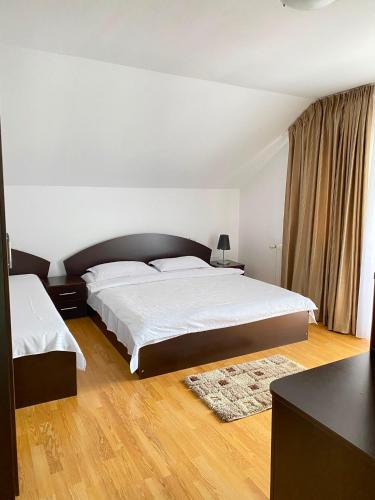 a bedroom with a large bed with white sheets at Pensiunea CARMEN Borșa in Borşa