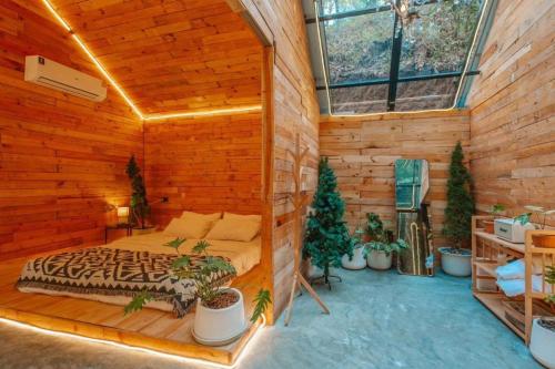 a bedroom with a bed in a wooden cabin at LOUVREFER in Ban Pa Pae