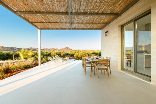 a dining room with a table and chairs on a patio at Sky And Stone Private Villa in Kathiana