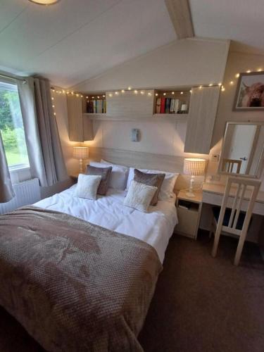 a bedroom with a large bed and a desk at 3-Bed Caravan Sleeps 7 with Indoor Pool in Wigton