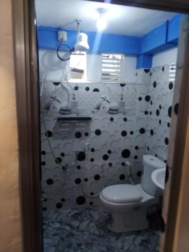 a bathroom with a toilet and a black and white curtain at RK guest in Nanu Oya