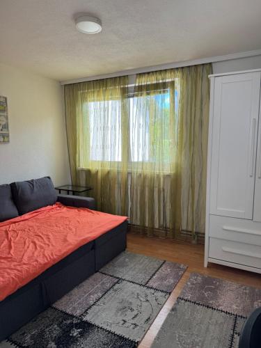 a bedroom with a red bed and a window at XXL apartman Free parking in Visoko