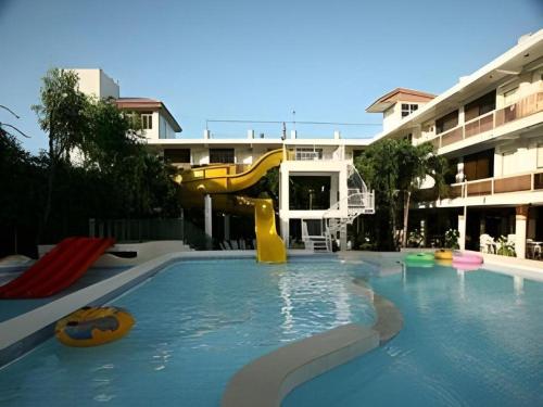 a swimming pool with a slide in a building at Splash Oasis Resort & Hotel in Forestry