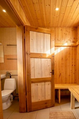 a bathroom with a toilet and a wooden door at Holiday Homes Eliza in Druskininkai