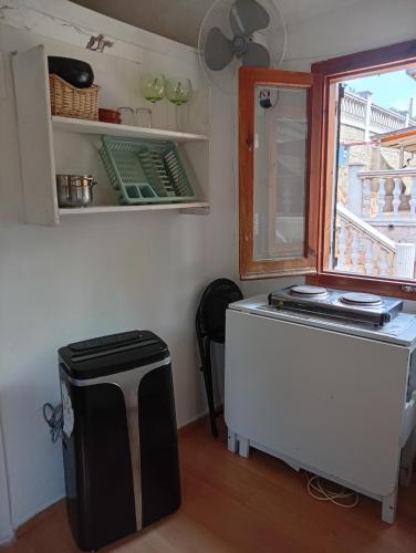a small kitchen with a refrigerator and a window at Castel bungalow in Palafolls