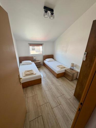 a small room with two beds and a window at VODICE KRAJE APARTMENTS in Vodice