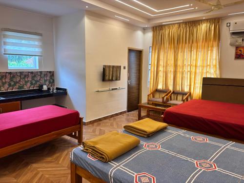 a hotel room with two beds and a couch at Gokarna City Guest House in Gokarna
